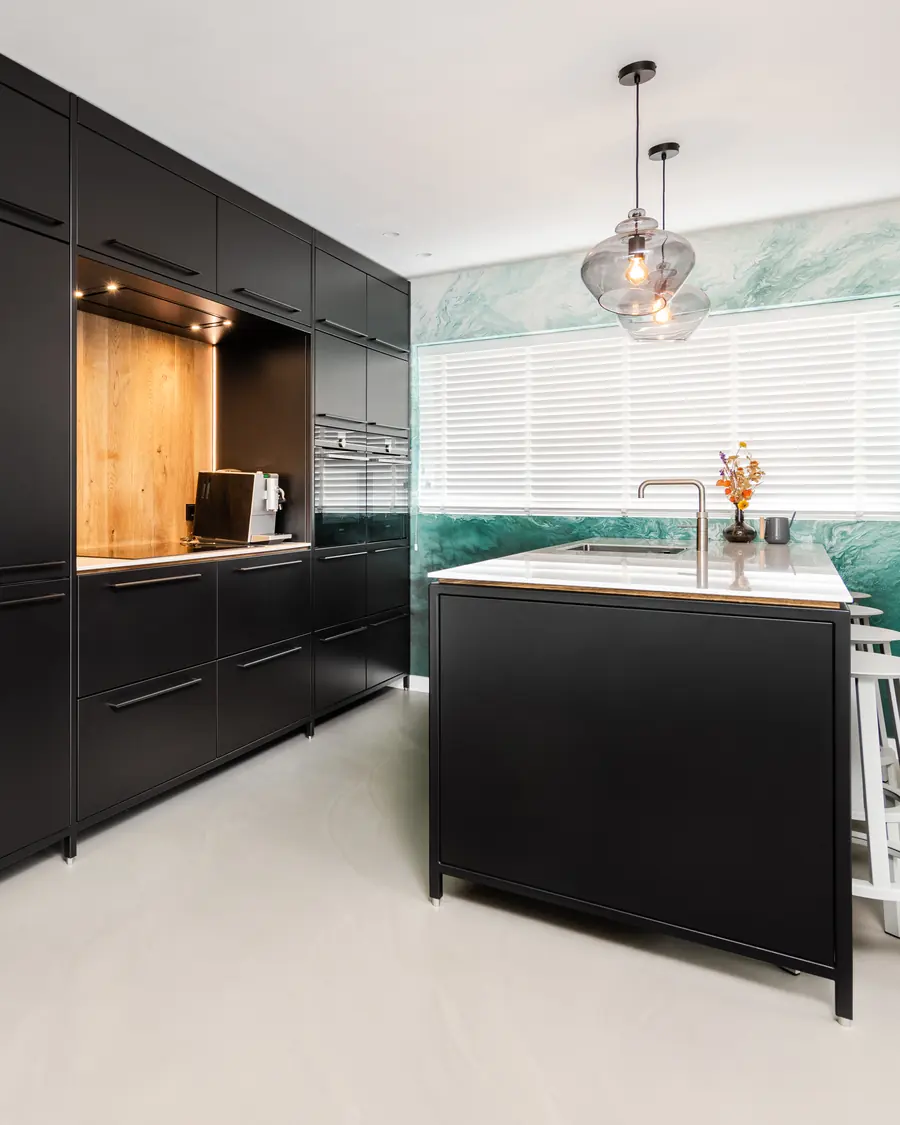Zwarte stalen keuken met een groene wand in een woning aan het water in Harderwijk