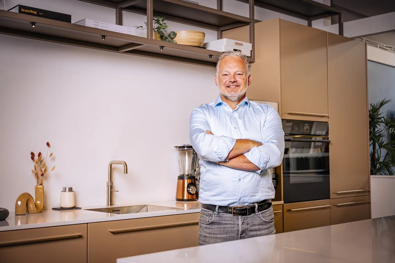 Henk van Veen met zijn armen over elkaar in de showroom