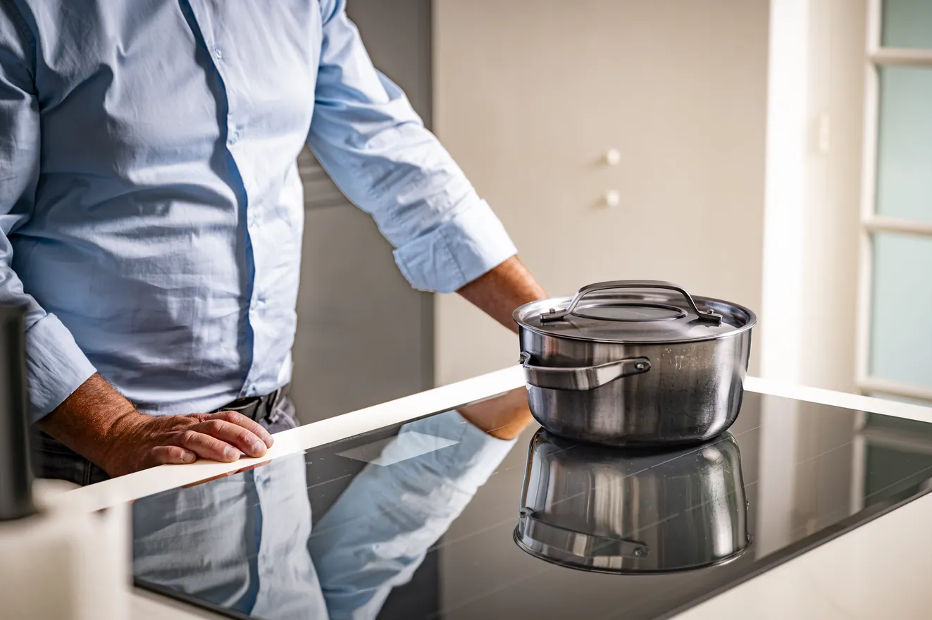 Een pan op de kookplaat van een keuken met een wit blad