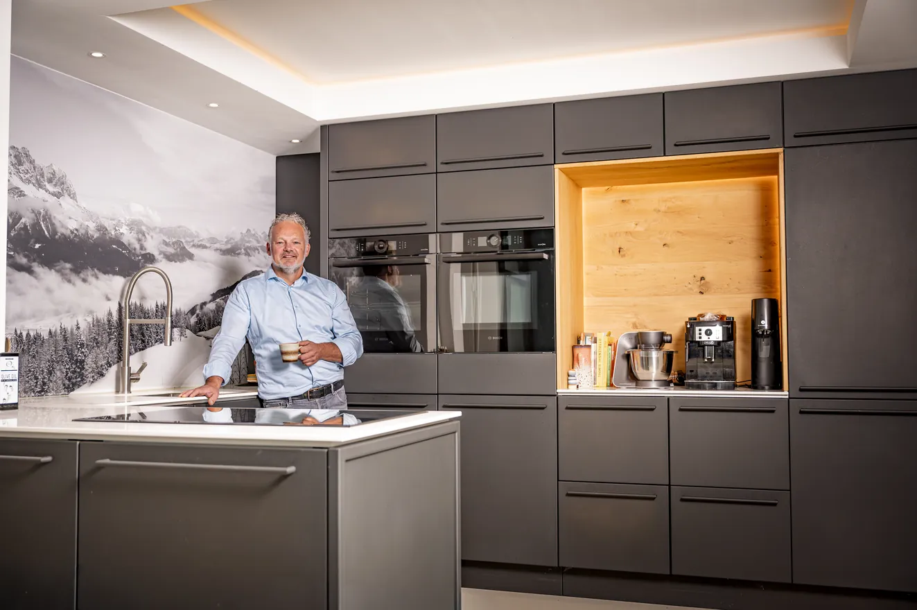 Een zwarte stalen keuken met een eiken nis, met Henk van Veen achter het kookeiland